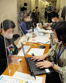 高齢者の新型コロナワクチン接種のネット予約を手伝う「お助け隊」(右)=神戸市中央区雲井通5、中央区役所 高齢者の新型コロナワクチン接種のネット予約を手伝う「お助け隊」(右)=神戸市中央区雲井通5、中央区役所