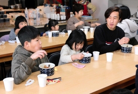 ブータン出身の男性(右端)と子どもたちが一緒にカレーを頬張る「こどもワクワク食堂」=国際交流シェアハウス「やどかり」 ブータン出身の男性(右端)と子どもたちが一緒にカレーを頬張る「こどもワクワク食堂」=国際交流シェアハウス「やどかり」