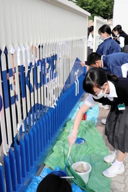 校門にペンキで丁寧にデザイン画を描く美術部員たち=神戸市兵庫区吉田町1、吉田中学校 校門にペンキで丁寧にデザイン画を描く美術部員たち=神戸市兵庫区吉田町1、吉田中学校
