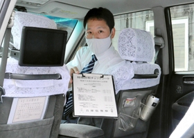 乗客が確認できるよう、助手席裏にステッカーが貼ってある。運転手が持つのは、特殊詐欺の手口が書かれたチェックシート=神戸市兵庫区三川口町2 乗客が確認できるよう、助手席裏にステッカーが貼ってある。運転手が持つのは、特殊詐欺の手口が書かれたチェックシート=神戸市兵庫区三川口町2