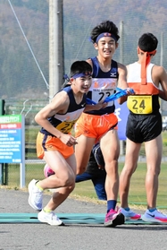 有野の4区阿津坂元気選手(右)からたすきを受け取る5区倉橋春都選手=豊岡市日高町(撮影・秋山亮太) 有野の4区阿津坂元気選手(右)からたすきを受け取る5区倉橋春都選手=豊岡市日高町(撮影・秋山亮太)