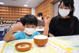 集中力を高めて箸でつかんだ豆をトレーに並べる子どもたち=神戸市中央区加納町6 集中力を高めて箸でつかんだ豆をトレーに並べる子どもたち=神戸市中央区加納町6