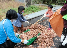 落ち葉を集める親子ら=神戸市東灘区向洋町中5 落ち葉を集める親子ら=神戸市東灘区向洋町中5