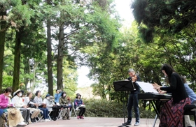 新緑に囲まれたステージで演奏を披露するマウロ・イウラートさんと佐野まり子さん=神戸市灘区六甲山町 新緑に囲まれたステージで演奏を披露するマウロ・イウラートさんと佐野まり子さん=神戸市灘区六甲山町