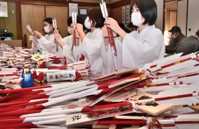 紅白の神矢に絵馬と短冊を取り付ける福娘たち=三木市大塚2 紅白の神矢に絵馬と短冊を取り付ける福娘たち=三木市大塚2