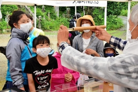 三木自然愛好研究会のメンバーの説明を聞きながら、興味津々に水中の生き物を観察する子どもたち=三木市細川町脇川 三木自然愛好研究会のメンバーの説明を聞きながら、興味津々に水中の生き物を観察する子どもたち=三木市細川町脇川