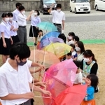 三木高校国際総合科の1年生は22日、文化祭で展示したカラフルな傘約60本を、兵庫県三木市加佐の小規模保育施設「リトルエンゼル」にプレゼントした。「スカイ・アンブレラ」と呼ばれるひもでつなげた傘で、受け取った子どもたちに笑みが広がった。