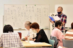 文字の成り立ちに関する解説を聞きながら文書の解読に取り組む参加者ら=市立中央図書館 文字の成り立ちに関する解説を聞きながら文書の解読に取り組む参加者ら=市立中央図書館