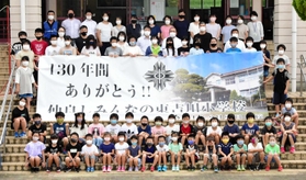完成した横断幕を囲む東吉川小の児童ら=三木市吉川町市野瀬 完成した横断幕を囲む東吉川小の児童ら=三木市吉川町市野瀬
