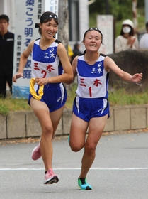 三木の1区田丸樹選手(右)からたすきを受け取った2区楠望咲選手=西脇市総合市民センター(撮影・笠原次郎) 三木の1区田丸樹選手(右)からたすきを受け取った2区楠望咲選手=西脇市総合市民センター(撮影・笠原次郎)