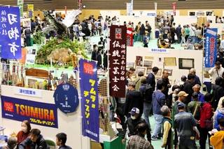 金物鷲(左奥)が存在感を示す会場は51社のブースと多くの来場客でにぎわう=三木山総合公園総合体育館