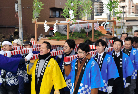 マグロをのせた御輿をかつぐ地元水産業者ら=柳原蛭子神社
