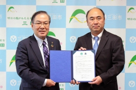 提携書にサインを交わした森哲男市長(左)と川崎大介球団代表=三田市役所 提携書にサインを交わした森哲男市長(左)と川崎大介球団代表=三田市役所