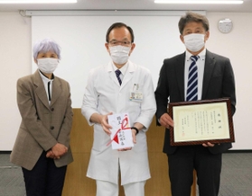 荒川創一院長(中央)に小切手を手渡した中西商店の太田正二社長(右)ら=三田市民病院 荒川創一院長(中央)に小切手を手渡した中西商店の太田正二社長(右)ら=三田市民病院