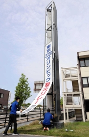 聖火リレーまでの日数を伝える懸垂幕を撤去する三田市職員=三田市三輪2 聖火リレーまでの日数を伝える懸垂幕を撤去する三田市職員=三田市三輪2