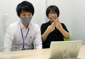 タブレット端末越しに聴覚障害者の質問に応じる担当課の職員(左)と手話通訳者=三田市役所 タブレット端末越しに聴覚障害者の質問に応じる担当課の職員(左)と手話通訳者=三田市役所