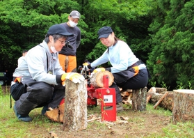 専用のカッターでまきを割る参加者=三田市大原 専用のカッターでまきを割る参加者=三田市大原