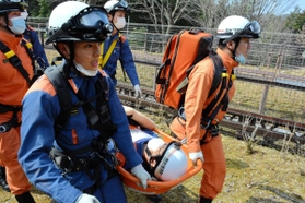 急病人役を担架に乗せて運ぶ宍粟消防署員たち=県立国見の森公園 急病人役を担架に乗せて運ぶ宍粟消防署員たち=県立国見の森公園
