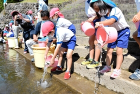 アユを放流する園児ら=宍粟市波賀町安賀 アユを放流する園児ら=宍粟市波賀町安賀