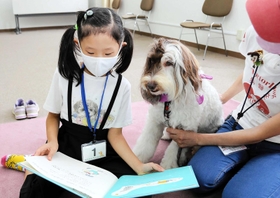 犬に絵本を読み聞かせる参加者=相生市立図書館 犬に絵本を読み聞かせる参加者=相生市立図書館