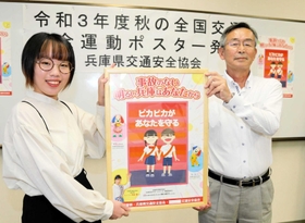 秋の全国交通安全運動のポスターに作品が採用された尾崎美和子さん(左)と、県交通安全協会の本岡康幸さん=龍野北高校 秋の全国交通安全運動のポスターに作品が採用された尾崎美和子さん(左)と、県交通安全協会の本岡康幸さん=龍野北高校