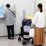 子連れで期日前投票をする女性=神戸市中央区雲井通5