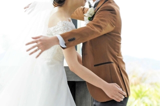 「自分たちらしい式にしたい」。キスの代わりにハグをする新郎新婦=神戸市内