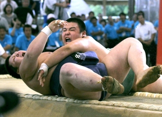 2011年8月21日、相撲個人決勝で中里の打越(左)を下手投げで下し、優勝を決めた報徳の佐藤=姫路市網干区、網干南公園相撲場