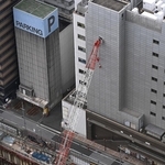 隣のビルに接触したクレーン=10日午後、神戸市中央区雲井通5