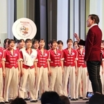 大阪・関西万博会場で「しあわせ運べるように」の合唱指揮をする臼井真さん=8日午前、大阪市此花区の夢洲