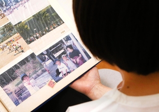 アルバムに残された釜谷圭祐さんの写真を見返す母の美佳さん=京都市