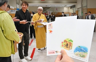 年賀はがきを購入した客に記念品を手渡す濱中治さんや桂きん太郎さん=30日午前、神戸市中央区栄町通6、神戸中央郵便局(撮影・斎藤雅志)
