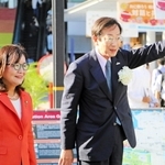 神戸市長選の選挙期間中、街頭演説のため、丸谷聡子・明石市長(左)と明石駅前に立った久元喜造氏=17日午前、明石市大明石町