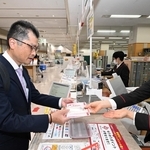 年賀はがきを購入する男性=30日午前、神戸市中央区栄町通6、神戸中央郵便局(撮影・斎藤雅志)