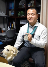 シドニー大会の銀メダルを手にする斉藤晃司さん=三田市武庫が丘4(撮影・名倉あかり) シドニー大会の銀メダルを手にする斉藤晃司さん=三田市武庫が丘4(撮影・名倉あかり)