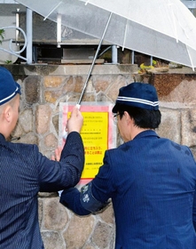 特定抗争指定暴力団に指定された山口組の総本部に標章を貼る捜査員ら=7日午前、神戸市灘区篠原本町4 特定抗争指定暴力団に指定された山口組の総本部に標章を貼る捜査員ら=7日午前、神戸市灘区篠原本町4