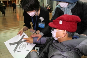 公演を前に凹凸をつけた「触図」で舞台装置の説明を受ける=西宮市高松町、兵庫県立芸術文化センター 公演を前に凹凸をつけた「触図」で舞台装置の説明を受ける=西宮市高松町、兵庫県立芸術文化センター