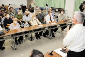 旧優生保護法の被害者支援条例案の否決を小林宝二さん(最前列の右から3人目)、喜美子さん(最前列左端)夫妻らに報告する泉房穂市長(手前)=明石市役所 旧優生保護法の被害者支援条例案の否決を小林宝二さん(最前列の右から3人目)、喜美子さん(最前列左端)夫妻らに報告する泉房穂市長(手前)=明石市役所