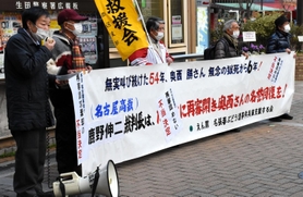 駅前を行き交う人々に事件や裁判の経緯を説明する「名張毒ぶどう酒事件兵庫支援する会」のメンバーら=JR元町駅前 駅前を行き交う人々に事件や裁判の経緯を説明する「名張毒ぶどう酒事件兵庫支援する会」のメンバーら=JR元町駅前