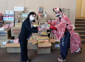 秋山秀行代表理事(右)から駄菓子を受け取る西口久代専務理事=神戸市中央区下山手通5 秋山秀行代表理事(右)から駄菓子を受け取る西口久代専務理事=神戸市中央区下山手通5