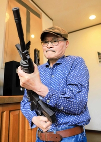 自動小銃をかたどった自作のオブジェを手にする榎忠さん。ずっしりと重い感覚を大切にしてきた=神戸市垂水区内 自動小銃をかたどった自作のオブジェを手にする榎忠さん。ずっしりと重い感覚を大切にしてきた=神戸市垂水区内