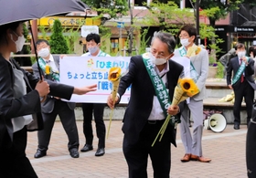 チラシと共にヒマワリを配る兵庫県弁護士9条の会のメンバーら=JR元町駅前 チラシと共にヒマワリを配る兵庫県弁護士9条の会のメンバーら=JR元町駅前