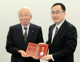 広東省の王曦副省長(右)から「友誼賞」のメダルを受け取る井戸敏三前兵庫県知事=神戸市中央区脇浜海岸通1 広東省の王曦副省長(右)から「友誼賞」のメダルを受け取る井戸敏三前兵庫県知事=神戸市中央区脇浜海岸通1