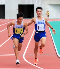 男子・須磨学園の1区国安広人(右)からたすきを受け取る2区林田蒼生=三木総合防災公園陸上競技場 男子・須磨学園の1区国安広人(右)からたすきを受け取る2区林田蒼生=三木総合防災公園陸上競技場