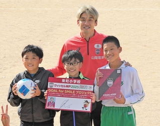 児童にボールを贈り、笑顔を見せる神戸の大迫(中央奥)=神戸市西区、東町小学校