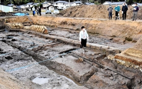 但馬国分寺跡の南東端の調査エリア。青色テープで示されているのが基幹水路跡で、手前右には地下排水溝の木材が残る=豊岡市日高町国分寺 但馬国分寺跡の南東端の調査エリア。青色テープで示されているのが基幹水路跡で、手前右には地下排水溝の木材が残る=豊岡市日高町国分寺
