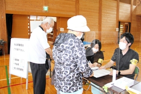 集団接種会場の受付で訪れた高齢者に対応する町職員ら=香美町村岡区川会 集団接種会場の受付で訪れた高齢者に対応する町職員ら=香美町村岡区川会