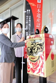 黒い獅子頭をあしらったポストをPRする町職員=香美町役場本庁舎 黒い獅子頭をあしらったポストをPRする町職員=香美町役場本庁舎