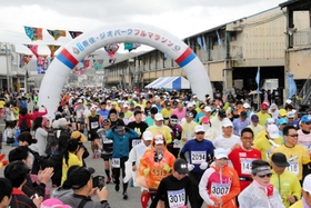 大漁旗がはためくスタート地点。日本海沿岸の景色が楽しめる大会には毎回約2千人が出場した=2019年4月27日、香住漁港西港 大漁旗がはためくスタート地点。日本海沿岸の景色が楽しめる大会には毎回約2千人が出場した=2019年4月27日、香住漁港西港