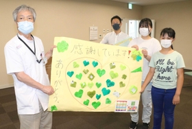 朝来医療センターの木山佳明院長(左)にメッセージを手渡す児童ら=朝来市和田山町法興寺 朝来医療センターの木山佳明院長(左)にメッセージを手渡す児童ら=朝来市和田山町法興寺